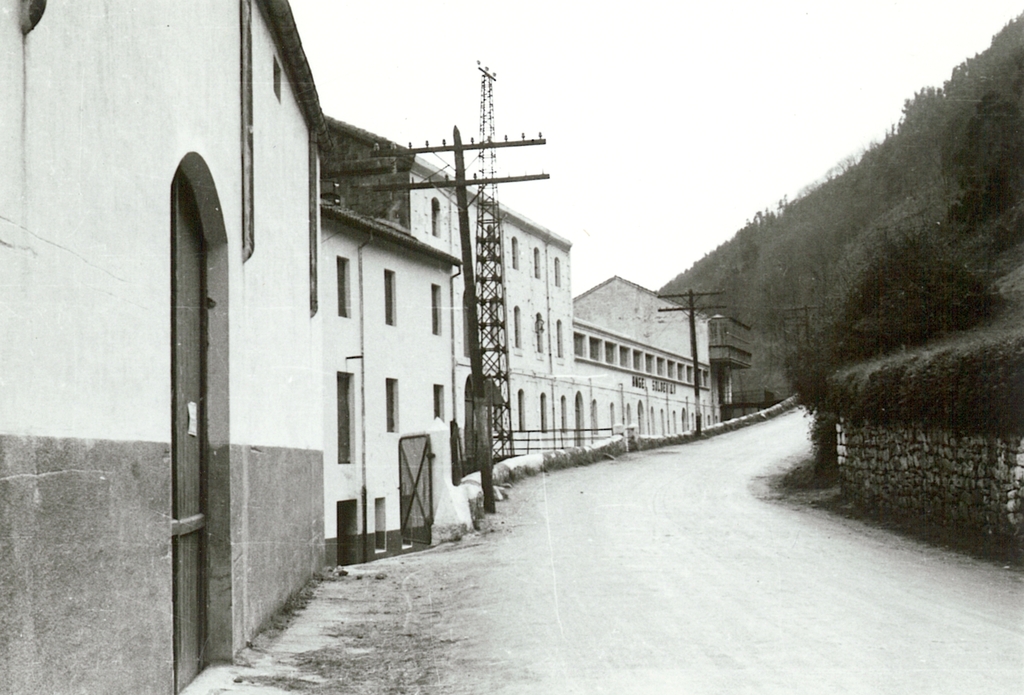 Carretera de acceso y fachada este de la fábrica